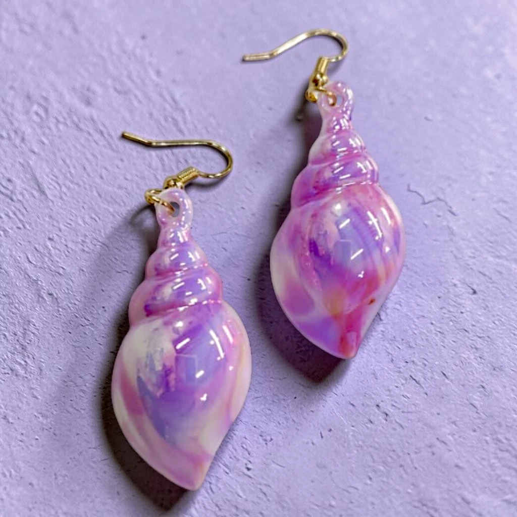 WhatsApp Image 2026-06-10 at 11.50.02 AM (1) aretes de caracola moradas tornasol - Image 1