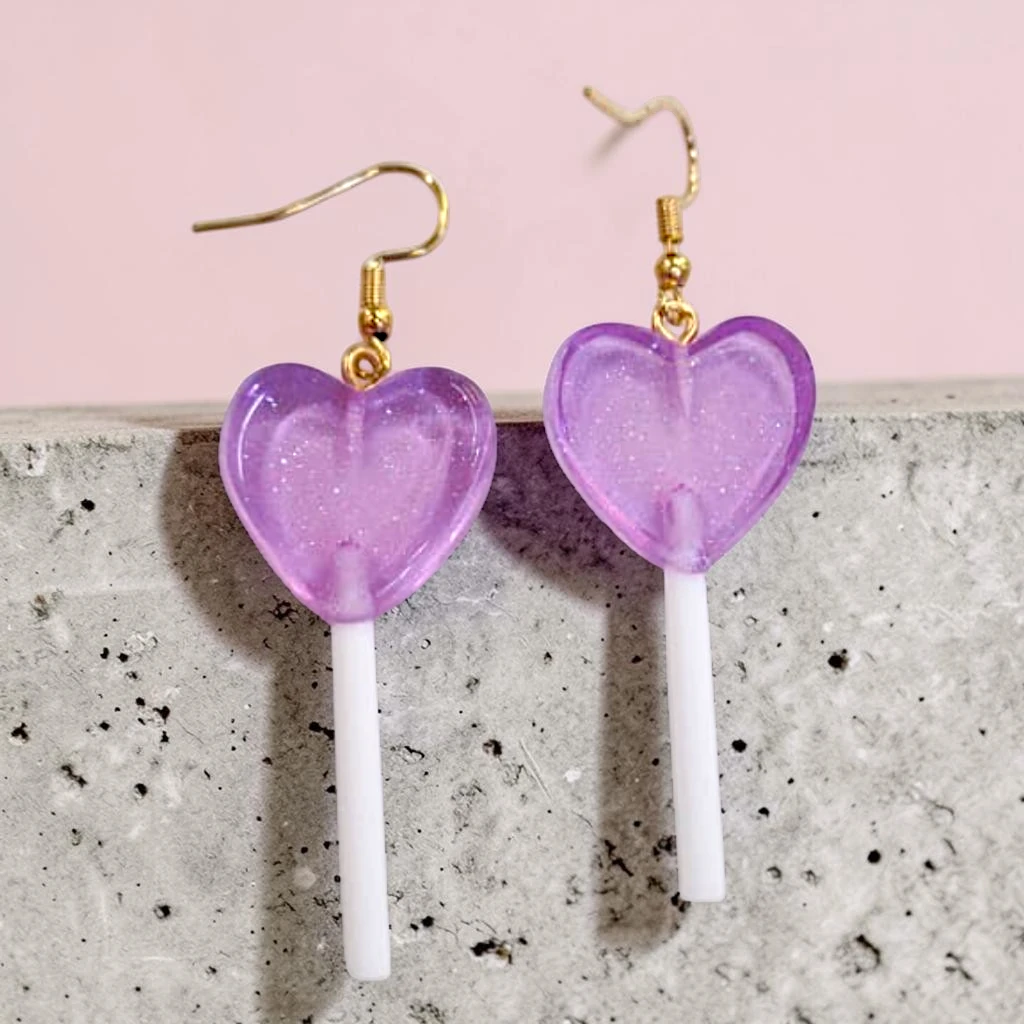 WhatsApp Image 2026-06-10 at 11.50.04 AM (1) aretes locos de paleta de corazón morados - Image 1