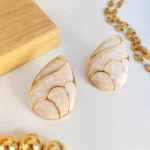 aretes de acero inoxidable blanco con dorado, contiene perla en forma de huevo