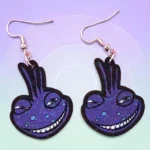 ARETES DE MDF MONSTRUO MORADO LAGARTIJA CON DESTELLOS