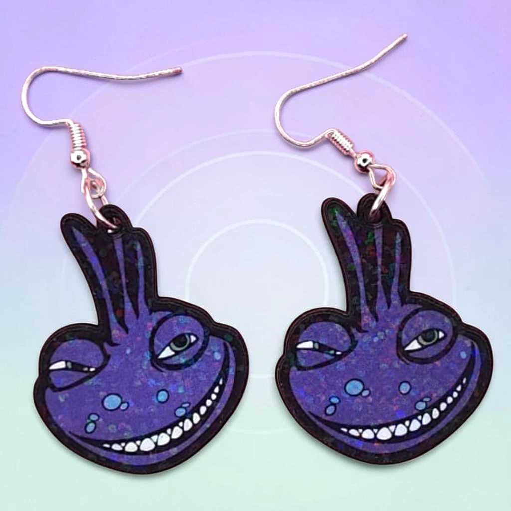 WhatsApp Image 2026-07-01 at 1.42.00 PM ARETES DE MDF MONSTRUO MORADO LAGARTIJA CON DESTELLOS - Image 1