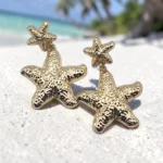 aretes con diseño de estrella de mar dorada