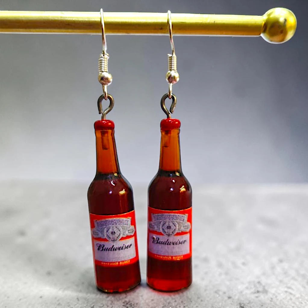 WhatsApp Image 2026-09-17 at 5.02.46 PM aretes de botella café con etiqueta roja - Imagen 1